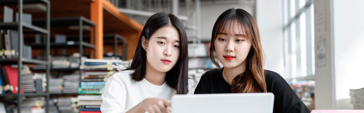 노트북을 보고 있는 여학생 둘